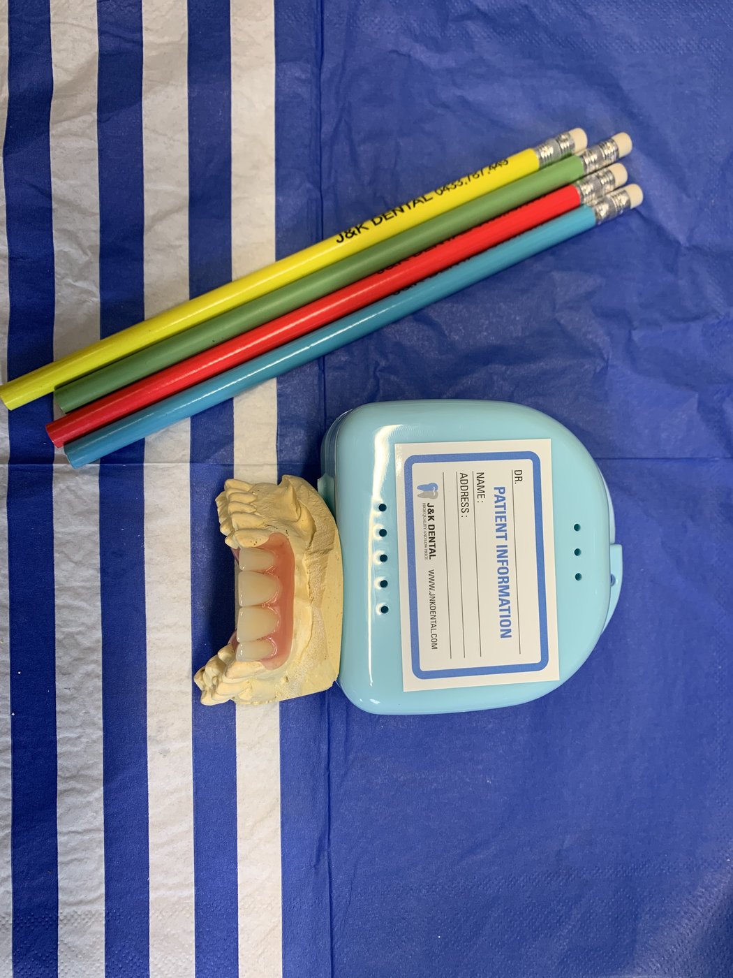 Dental model with patient case and marking pencils